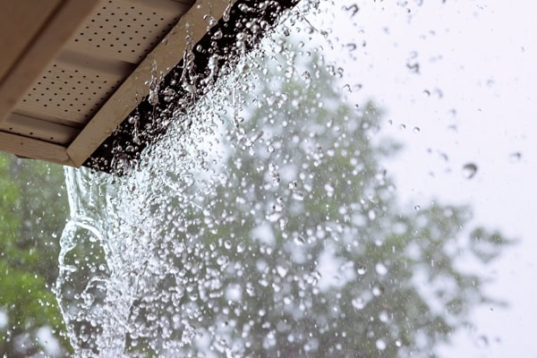 Gutter water overflowing during heavy rain in Hudson Valley.